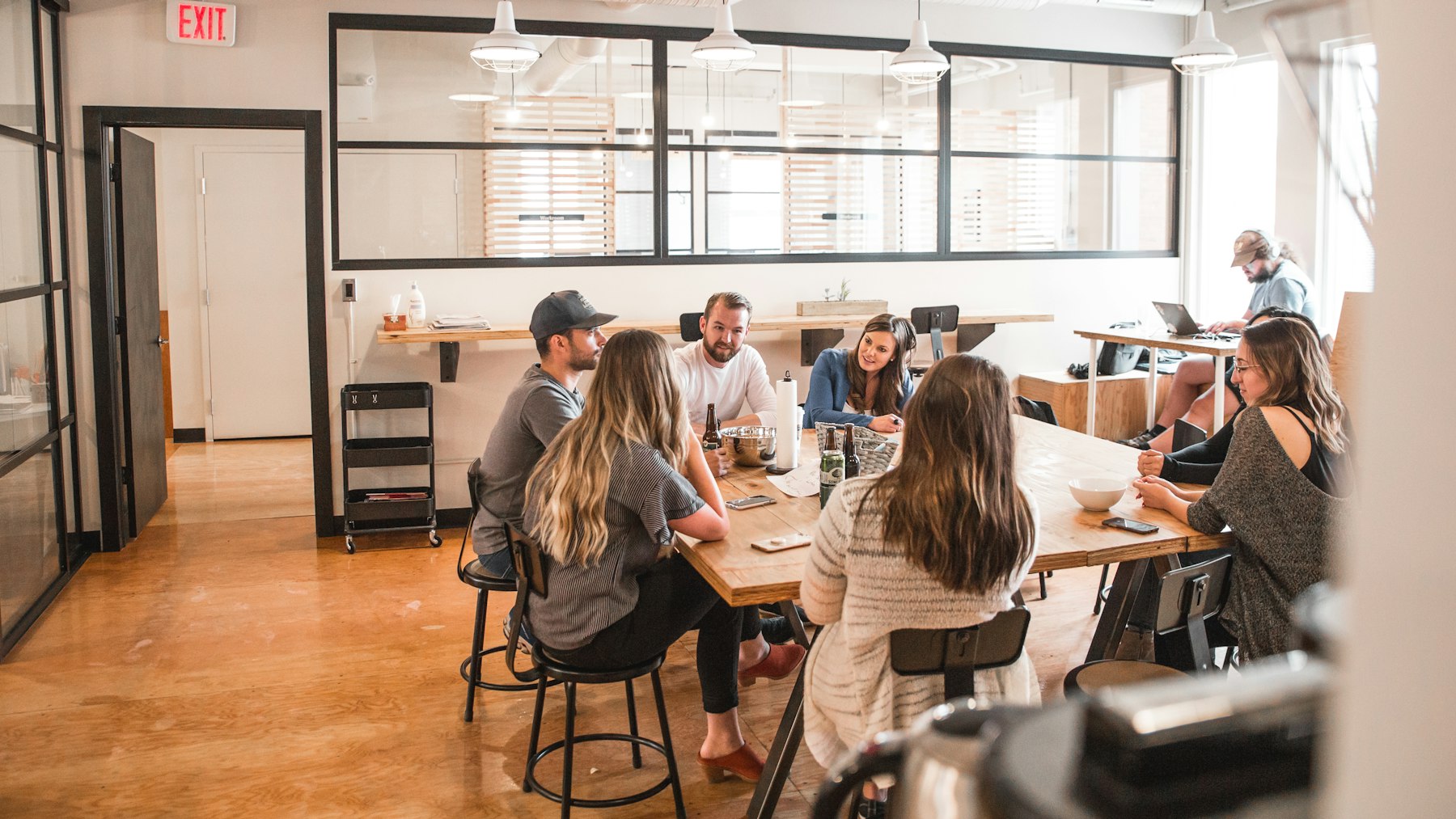 Adultos reunidos em uma mesa de trabalho colaborativo